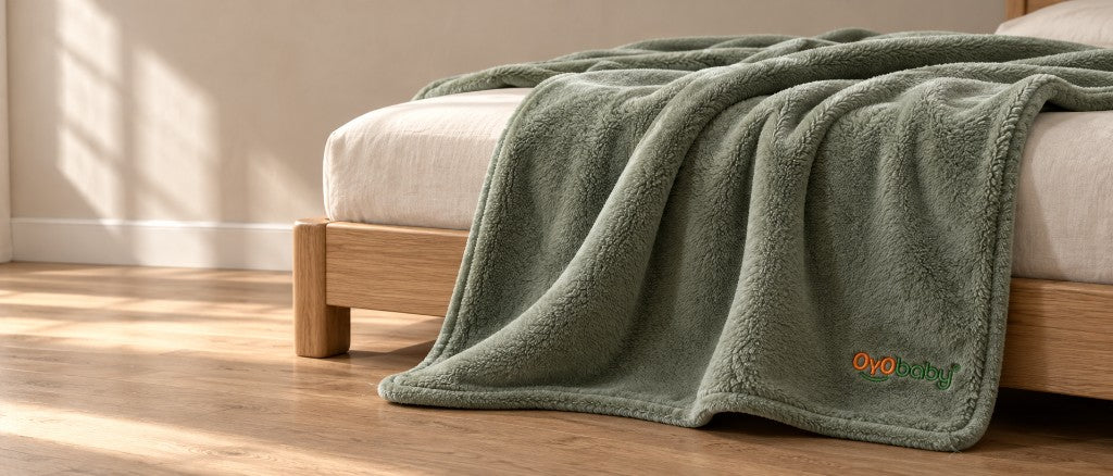 Sage OyoBaby blanket draped over a bed